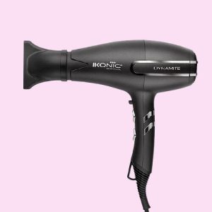 "Professional hair dryer with nozzle attachment placed on bathroom counter"